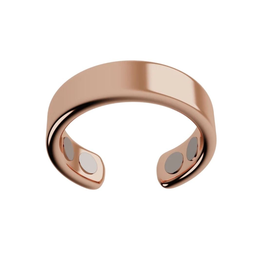 El Anillo de Magnoterapia - Alivio para la menopausia en color oro rosa, con acabado pulido y banda abierta, integra cuatro imanes circulares internos para ayudar a aliviar síntomas de la menopausia. Presentado sobre fondo blanco liso.